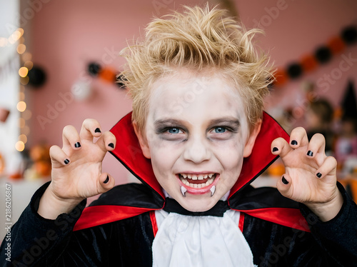 Young boy in vampire costume for Halloween party, spooky child dressed as a bloodsucker.