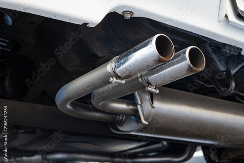 Foto Low angle view of dual chrome exhaust pipes mounted under rear bumper of white car