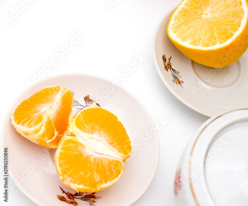 Oranges and a lemon on plates.