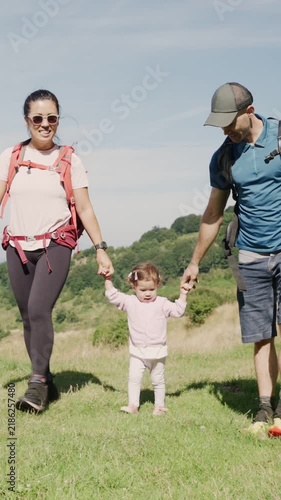 Multiethnic family walking holding hands with their daughter
