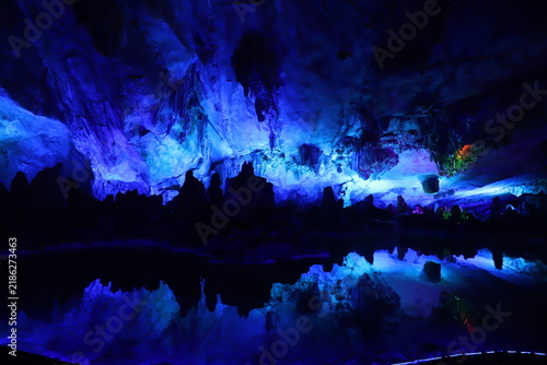 Bild auf Leinwand Colorful illuminated limestone cave with stalactite formations