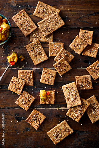 Homemade Seeded Crackers with Piccalilli on Rustic Wooden Table Overhead