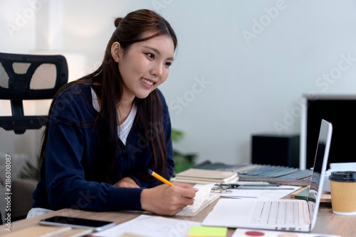Asian Professional Woman Working on Creative Furniture Design Project in Modern Office Workspace