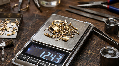 Professional metal ring sizing mandrel with graduated measurements on wooden jeweler workbench