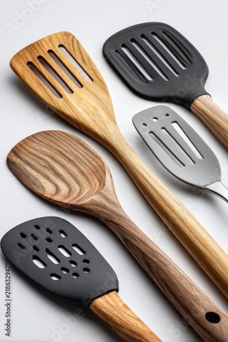 Close-up of kitchen spatulas showing different materials and textures on a white background