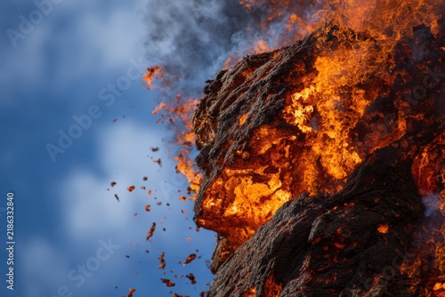 Huge burning lava against blue sky background during active volcanic eruption