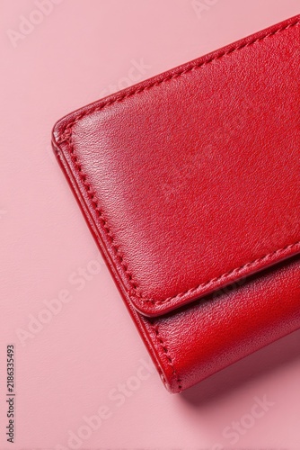 Modern red wallet on a pale pink background with space for text