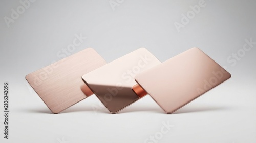 Three blank rose gold metal credit cards floating in the air