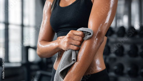 Athletic woman wiping sweat from arms with towel after training in sports gym sweaty arms fitness gym active woman workout routine fitness lifestyle female athlete body fitness gym gear