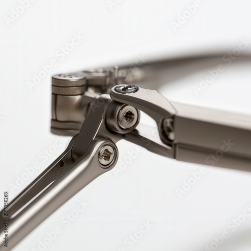 Close up of metal mechanical linkage with screws on a white background
