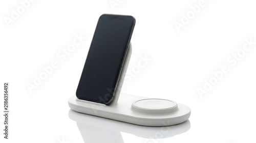 Smartphone charging on a white wireless dock station isolated on white