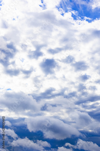 dark gray rainy clouds cover sun in dark blue sky