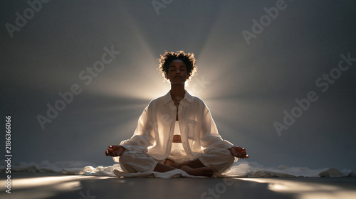 Serene Woman Meditating in Lotus Pose with Backlight