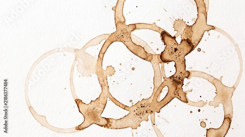 A close-up view of coffee stains on a white surface, forming abstract circular patterns.