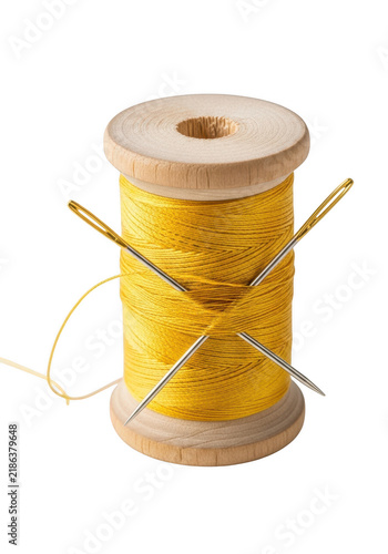 Yellow thread spool with orange sewing needles