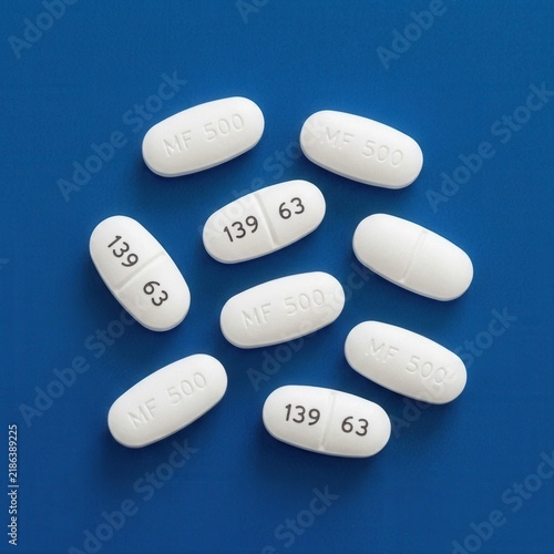 Pharmaceutical Pills Scattered On A Vibrant Blue Background Studio Shot