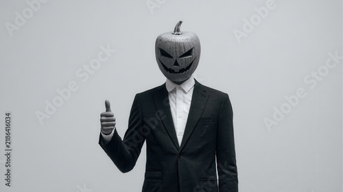 Pumpkin headed figure in suit giving thumbs up