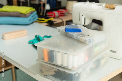 Foto A sewing machine on a workbench with fabric and storage container for professional crafting