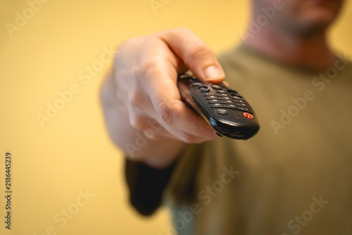 Obraz na płótnie Hand pointing a TV remote control forward