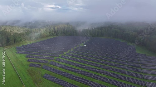Aerial View of Solar Farm Surrounded by Forest and Morning Mist in Latvia