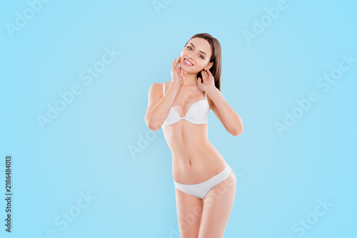 Cosmetics beauty salon shop concept. Portrait of skinny thin slender woman in underlinen touching her flawless sensitive sensible clean clear skin with palms isolated on white background