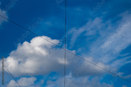 Sky view with clouds and power lines during the day in an open area