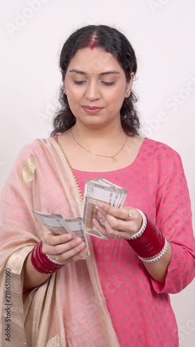Vertical Shot of Married Indian Woman Counting Cash Indian Rupee (INR) Notes