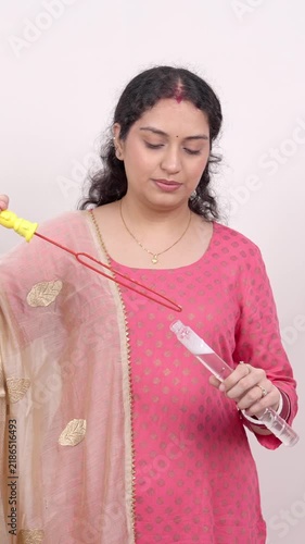 Vertical Shot of Happy Married Indian Woman in Pink Kurta Playing with Soap Bubbles