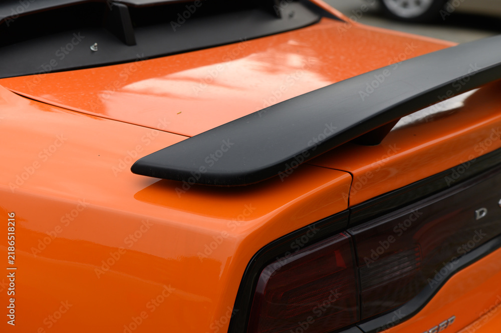 Fototapeta premium Commercial stock photo of a modern orange sports car rear spoiler detail
