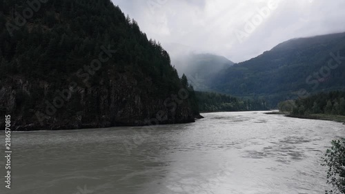 Scenic River Flowing Through Lush Green Forests and Majestic Mountains in British Columbia, Canada