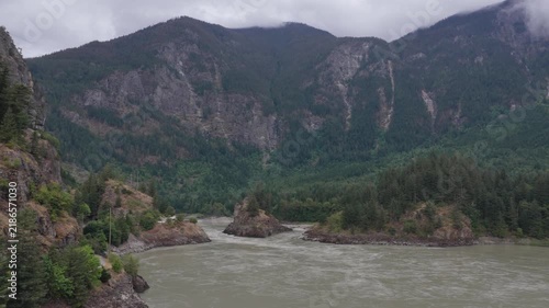 Majestic River Flowing Through Lush Forests and Towering Mountains in British Columbia, Canada