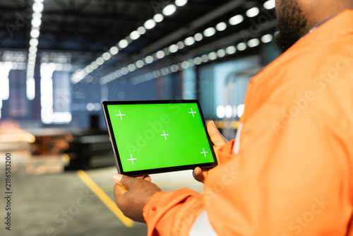Tablet mockup beside black supervisor and metalworking tools