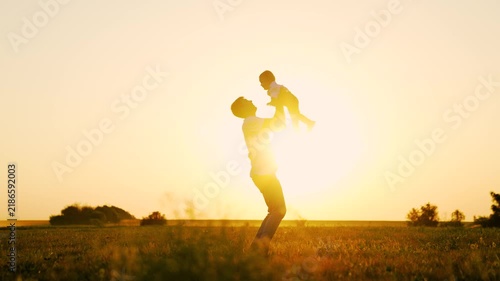 Dad throws happy little son into sky, sun. Family game, dad child love. Father plays with child in park, kid son dreams flying becoming pilot. Happy family, childhood dream fly. Father child outdoors