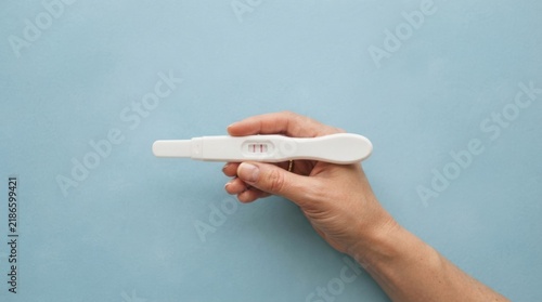 Pregnancy Test with Two Lines Held by Hand
