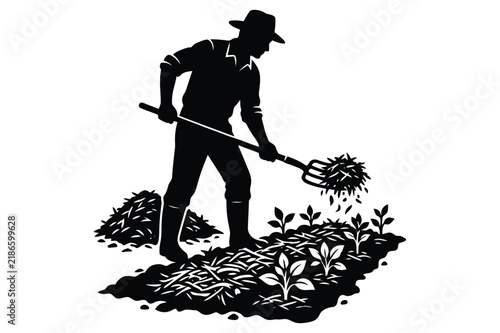 Farmer using a pitchfork to turn compost in a small garden bed with pitchfork