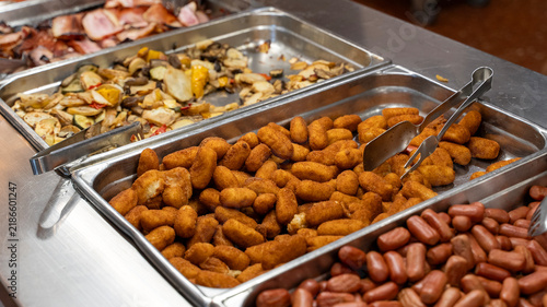 Foto Hotel breakfast buffet with crispy croquettes sausages and roasted vegetables