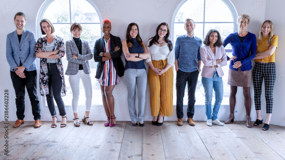 Fototapeta premium Diverse group of men and women standing together in a bright studio