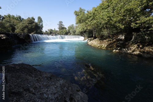 Turquoise waters of Manavgat Waterfall surrounded by lush green nature, popular tourist destination in Antalya