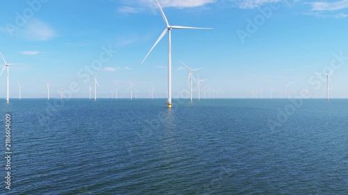 Aerial drone view of an offshore wind farm station in the sea. Modern renewable energy turbines generating clean electricity and sustainable alternative power in the ocean.