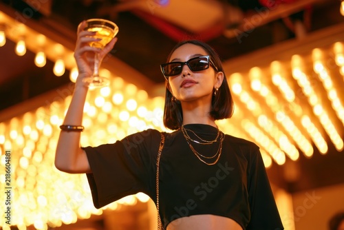 Confident Gen Z Woman Raising Cocktail With Glamorous Style
