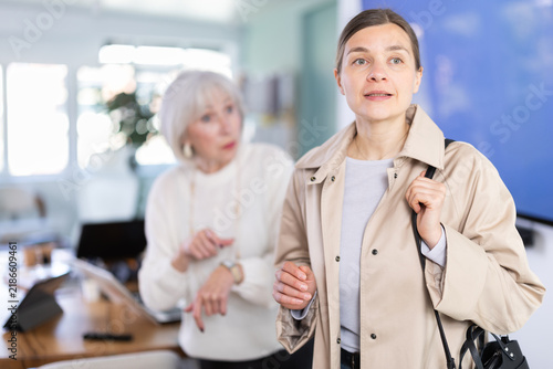 Quadro su tela Elderly woman sternly scolds her adult female colleague for being late for work
