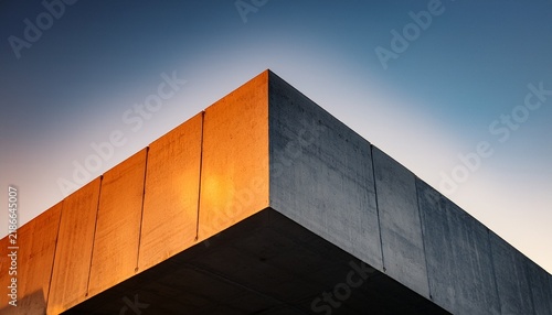 modern concrete structure with warm light illuminating sharp geometric angles