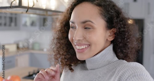 African American woman entering speaking and smiling into cell greeting viewers at kitchen island
