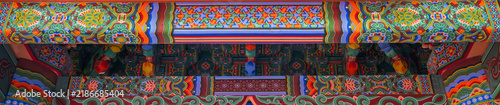 Fotografía Intricate Dancheong patterns and colorful lotus motifs adorn the wooden beams and rafters of a traditional Korean temple pavilion