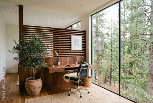 Modern Minimalist Home Office with Slatted Wood Wall and Forest Views