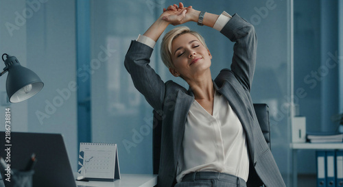 Young woman stretching and relaxing in a modern office environment  