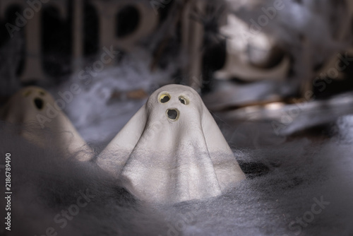Handmade clay ghost figurine displayed charming Halloween decoration. Handcrafted ceramic character features minimalist design with expressive facial details. Natural clay material, artisan