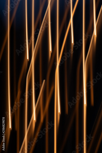 Fotografía Vertical low-key photograph of abstract warm golden light streaks created with intentional camera movement (ICM)