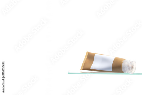 Foto An empty, unbranded, cosmetic tube with a gold-brown finish and clear flip cap