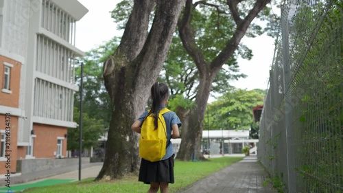 Young asian student girl walking to school in the morning